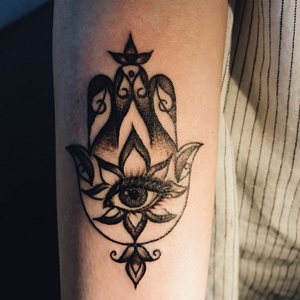 Black and white hamsa tattoo on the arm.