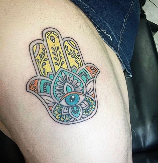 Colorful hamsa tattoo on the thigh.