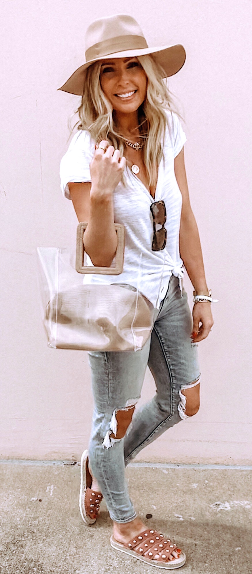 White top, gray distressed denim and brown sun hat.