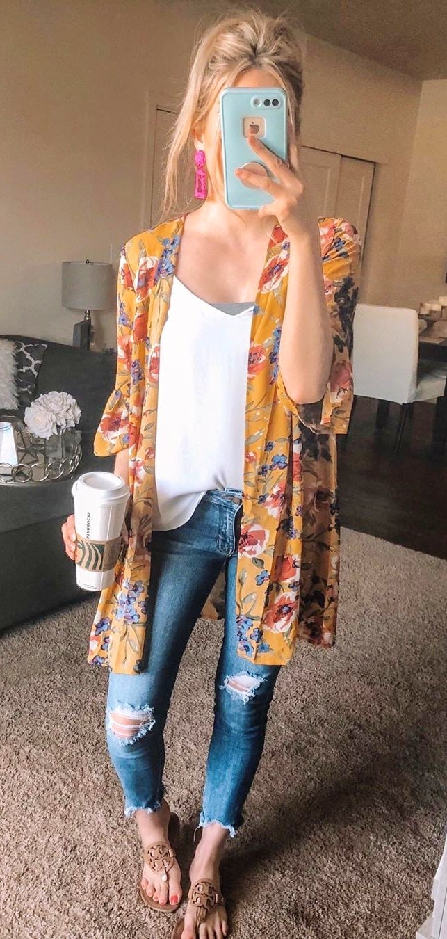Blue ankle length distressed jeans, yellow and red cardigan and white top.