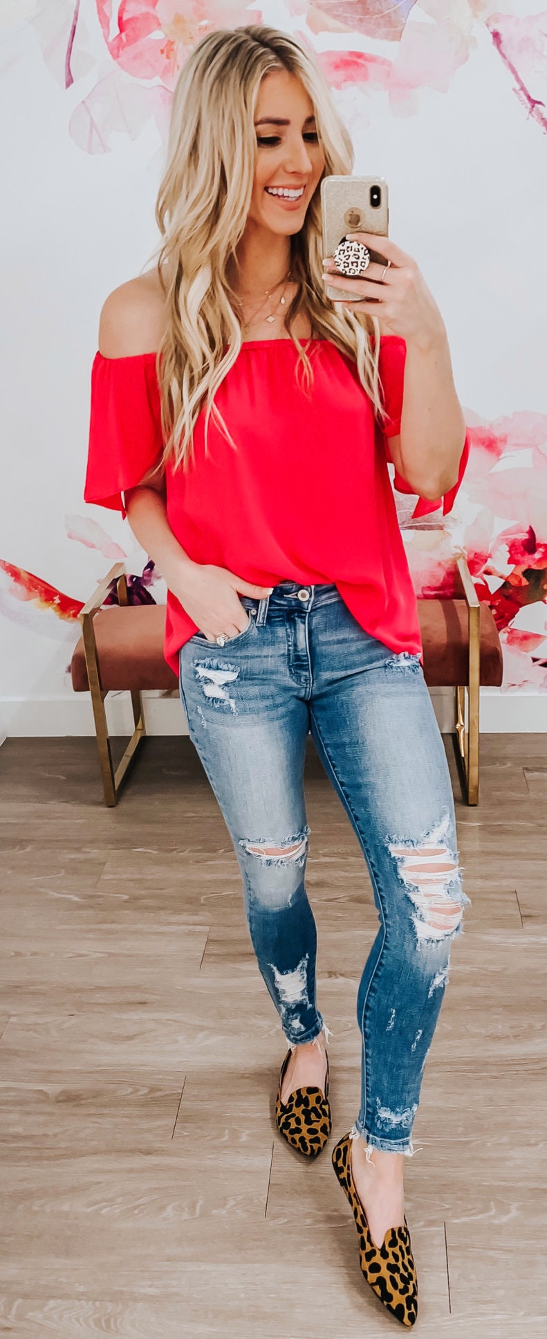 Blue distressed jeans and red off-shoulder top.