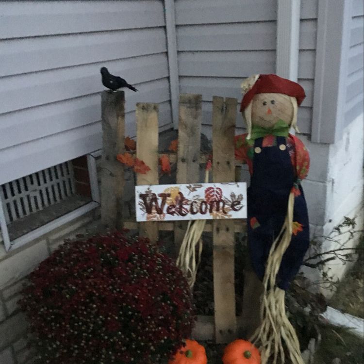 Autumn decor for the yard including an adorable scarecrow!
