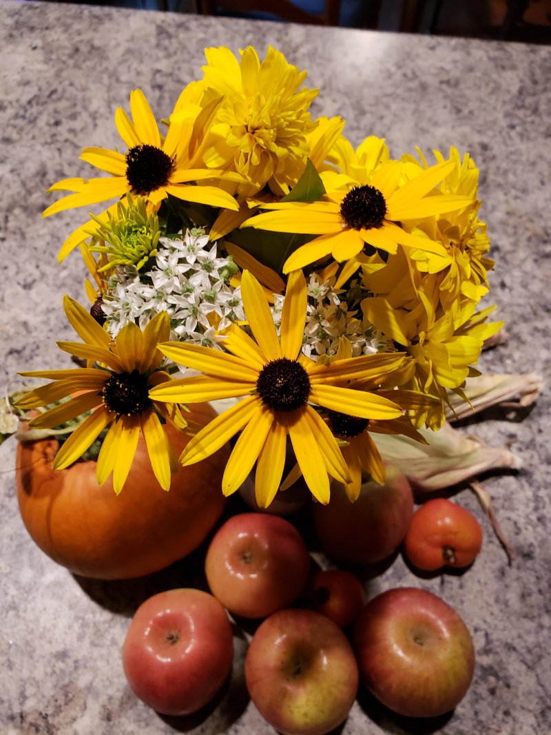 Fall daisies, chive flowers, sugar pumpkin, and apples.