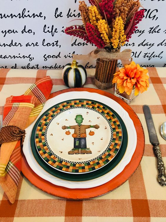Halloween tablescape with Frankenstein scarecrow plate and plaid tablecloth for fall fun.