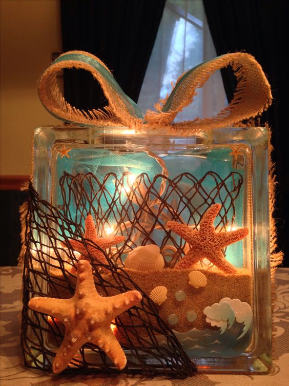 Beach theme glass block with sand, lights, net, and burlap.