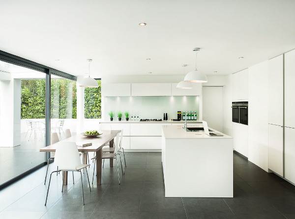 Dark gray, extra large matt tiles are used both indoors and outdoors in this home to create seamless flowing spaces.