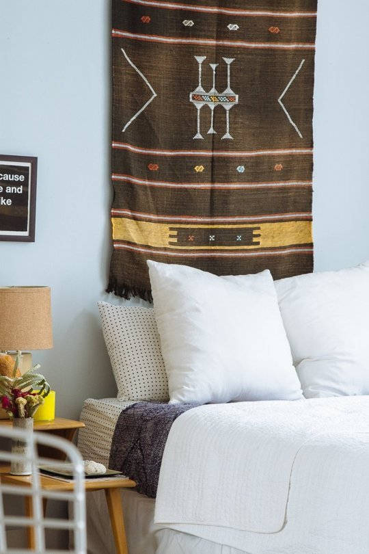 Hang a tapestry or colorful rug behind your bed