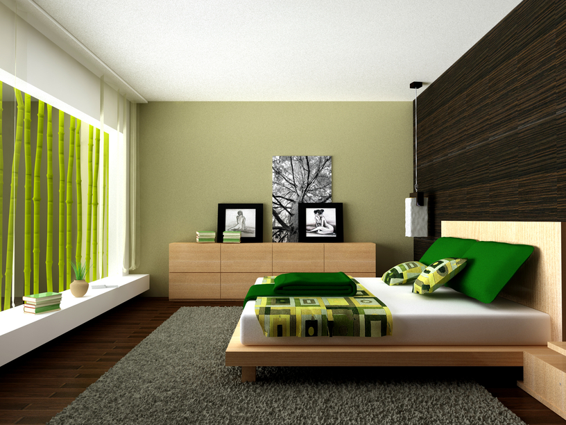 Sleek low bed on large rug over dark wood floor with green color scheme