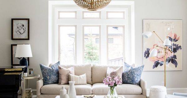 Feminine living room with a beige sofa and gold woven pendant