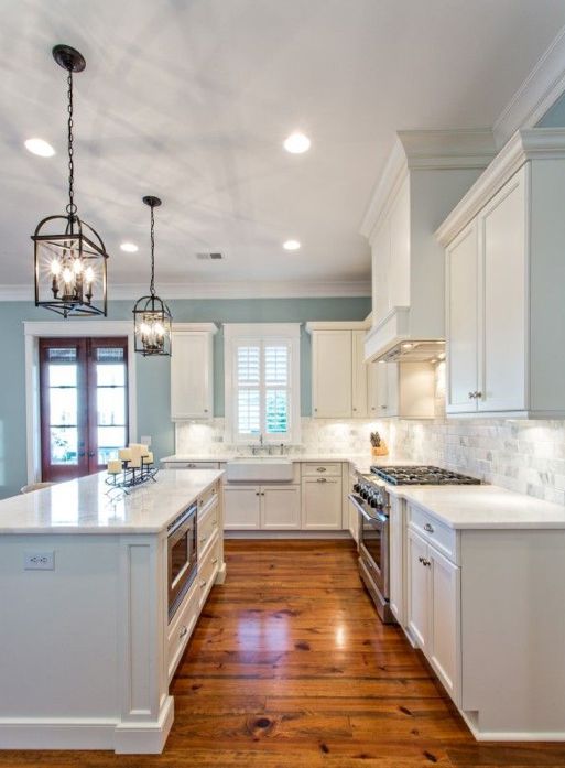 Raindrop blue kitchen with white cabinets and lantern chandeliers
