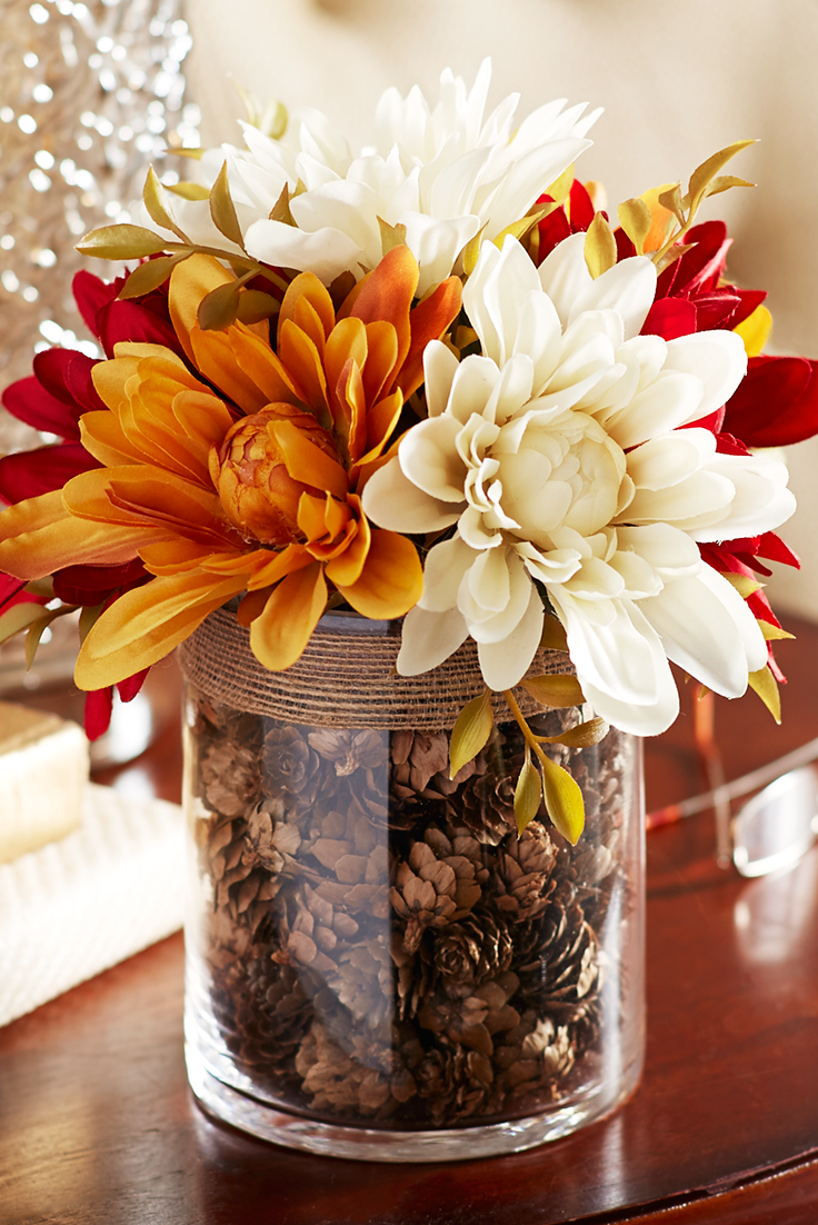 Faux dahlias in a vase filled with pinecones makes perfect tabletop focal point.