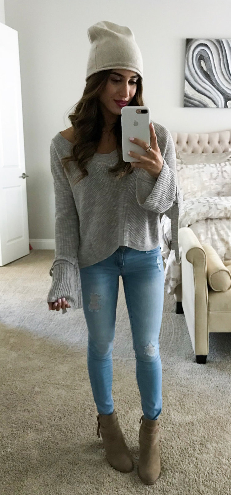 women's gray sweatshirt, gray hat, and blue-washed jeans