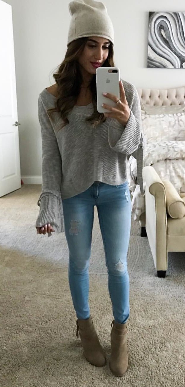women's knitted gray scoop-neck sweatshirt and stone-washed distressed blue denim jeans