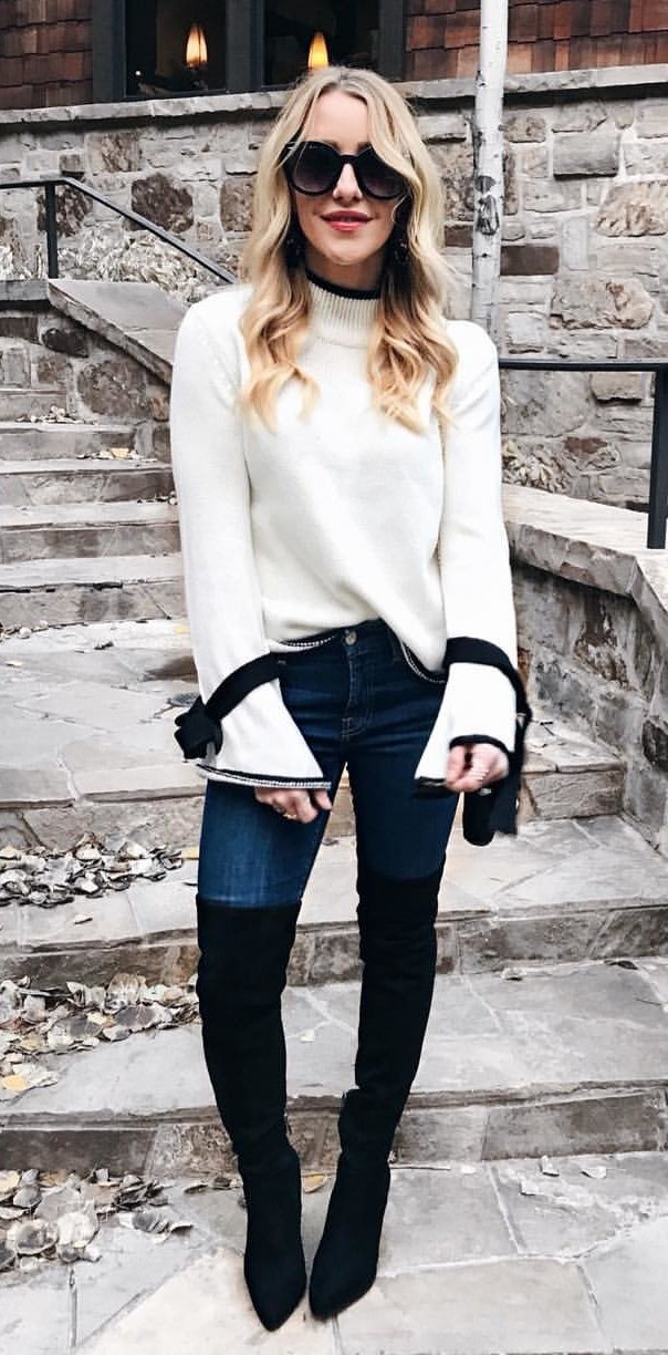 women's white sweater and blue-washed jeans