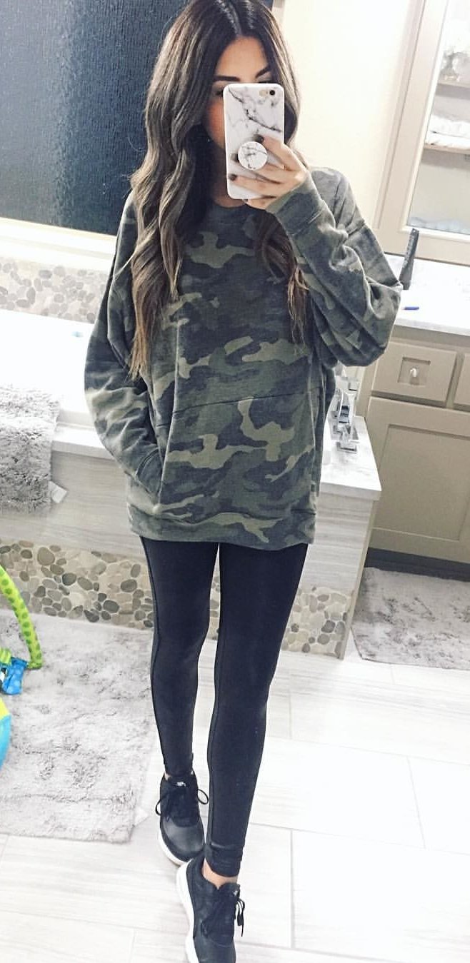 women's woodland camouflage hoodie, black leggings, black-and-white shoes, and white android smartphone