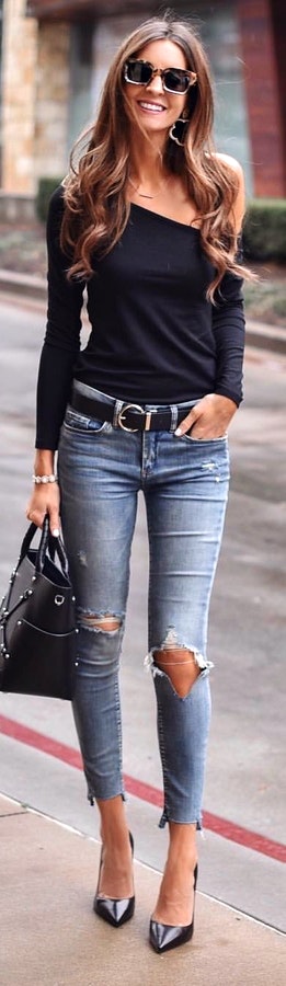 Black long-sleeved shirt and distressed blue denim jeans.