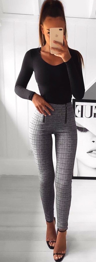 Black scoop-neck long-sleeved shirt and gray pants standing near poster. Pic originally posted by fashion.world_blog