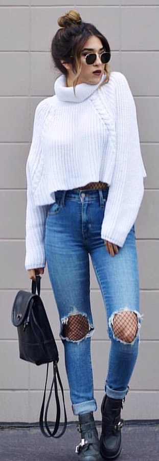 Cable knit long-sleeved turtleneck top with distressed blue fitted jeans.