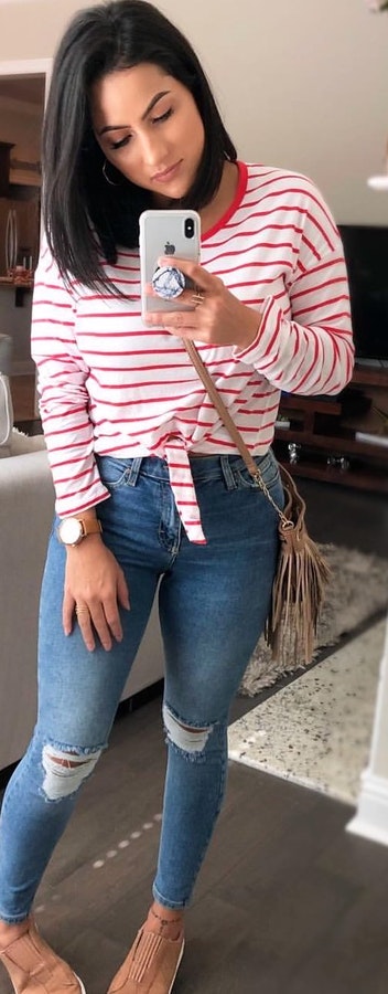 White and red stripe scoop-neck long-sleeved shirt and distressed blue fitted jeans.
