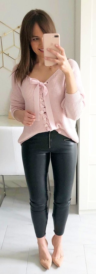 pink lace-up long-sleeved shirt and black leather pants.