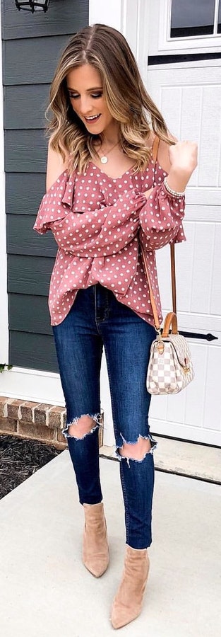 red and white polka-dot cold-shoulder shirt with blue denim jeans.