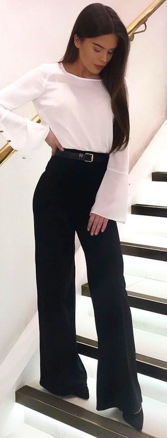 white scoop-neck long-sleeved shirt and black pants.