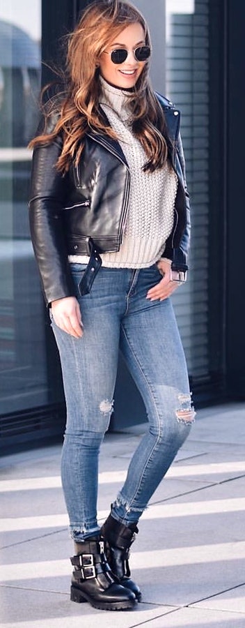 Black biker jacket, distressed blue jeans and pair of black boots.