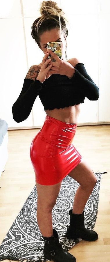 Black long-sleeved crop top with red mini skirt outfit.