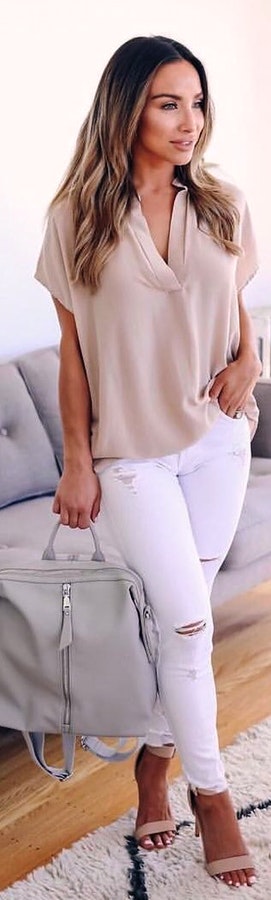 Gray v-neck shirt and distressed white denim jeans.