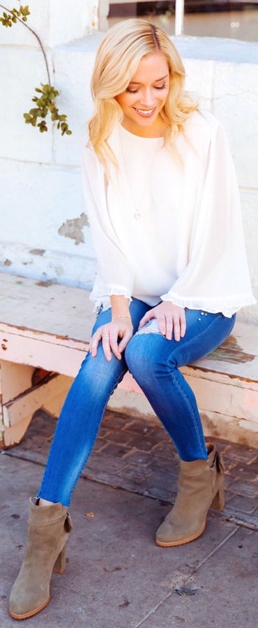 White long-sleeved blouse and blue denim pants outfit.