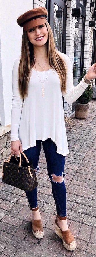 White scoop-neck long-sleeved blouse and distressed blue denim jeans at daytime.