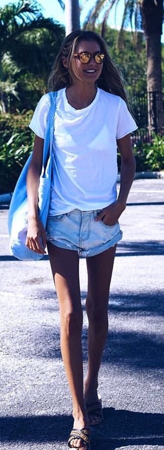 White t-shirt, acid-washed short shorts and pair of sandals outfit.