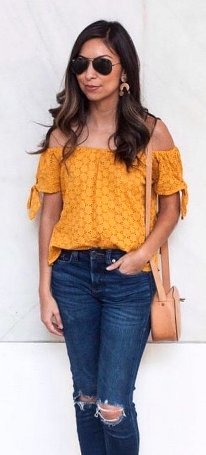 Yellow floral off-shoulder shirt and distressed blue denim bottoms.