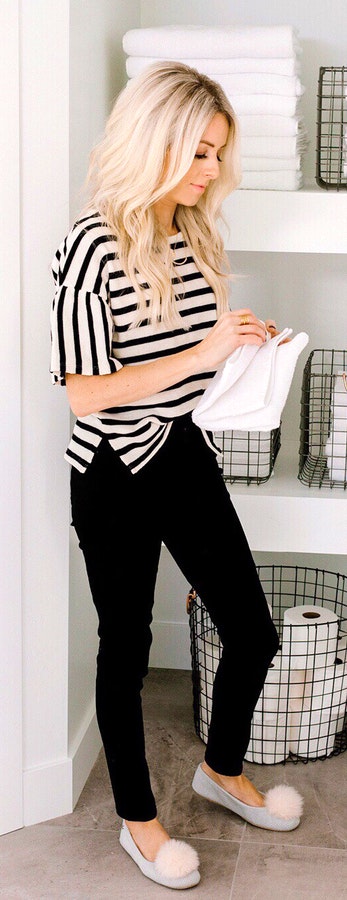 Black and white stripe top standing near wall.