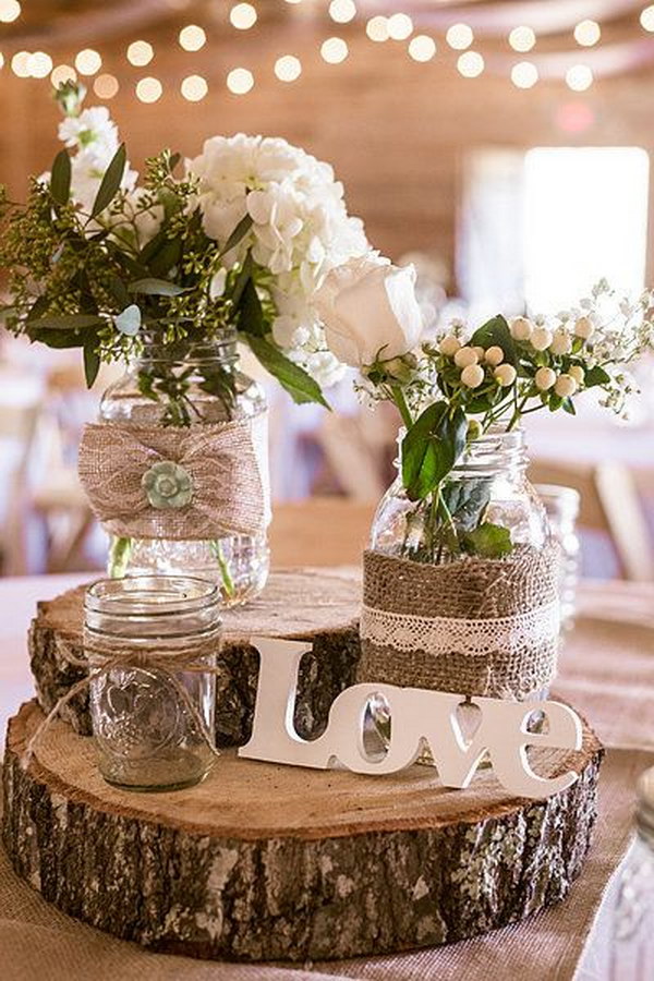 Burlap-Wrapped Mason Jars Stacked atop Tree Trunk Slices