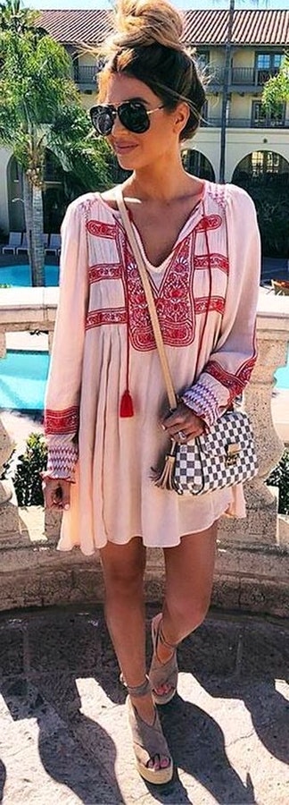 Woman in white and red long sleeved split neckline dress.