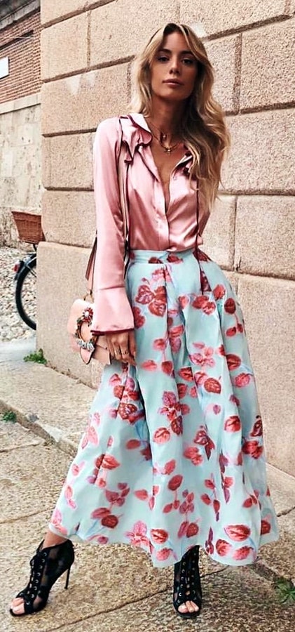 Woman wearing pink dress shirt blue and red floral skirt and black peep toe heeled sandals.