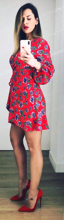 Woman wearing red and green floral mini dress.