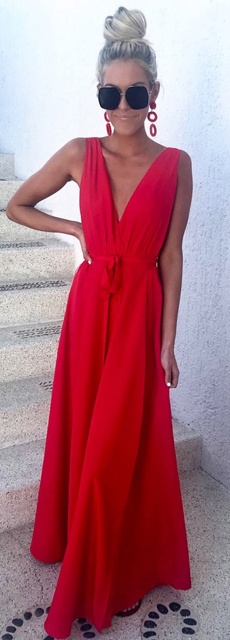 Woman wearing red v neck sleeveless dress.