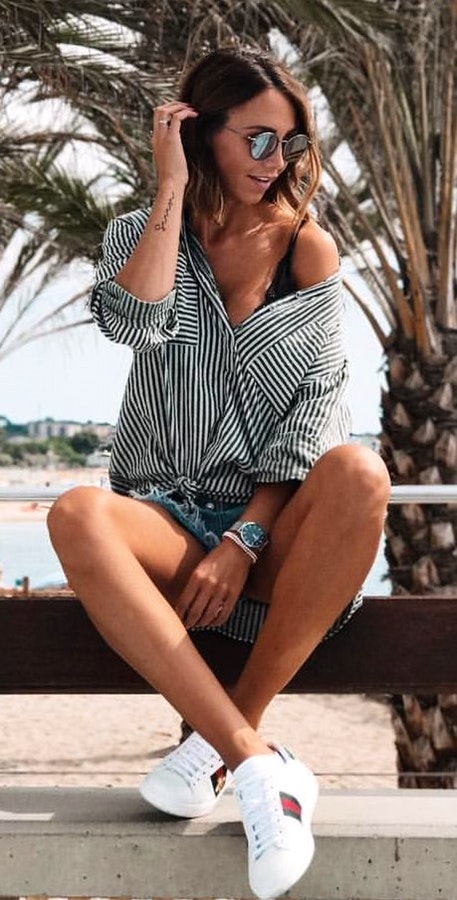 Women's white and black vertical striped long-sleeve shirt and gray short shorts.