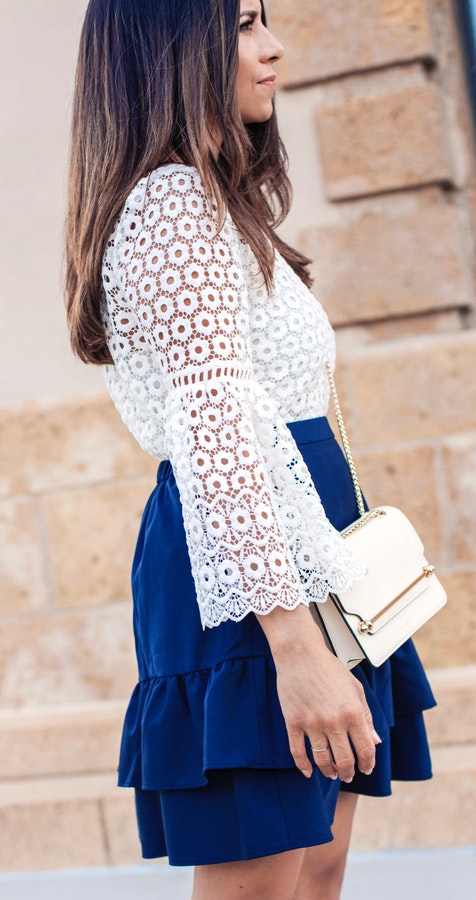 Women's white lace bell-sleeve top and ruffled blue skirt.