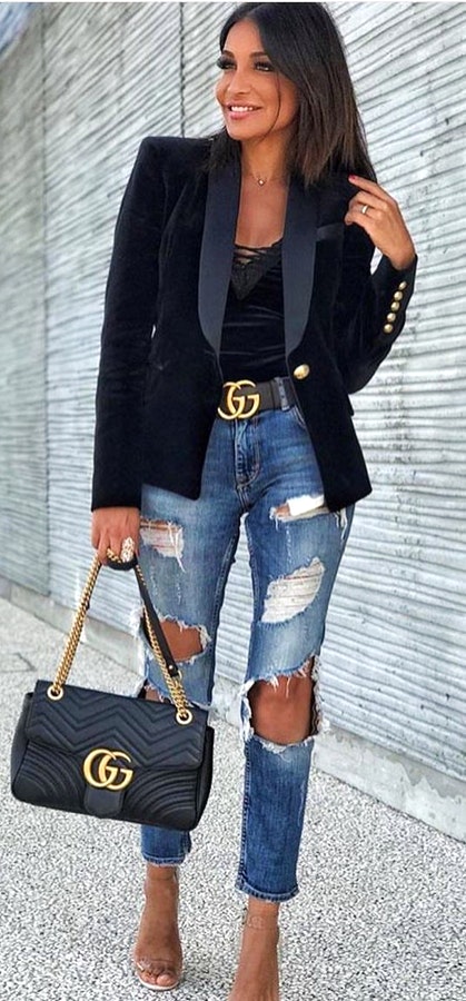 Women's black blazer, distressed blue denim jeans, black Gucci leather belt, and black Gucci leather handbag.