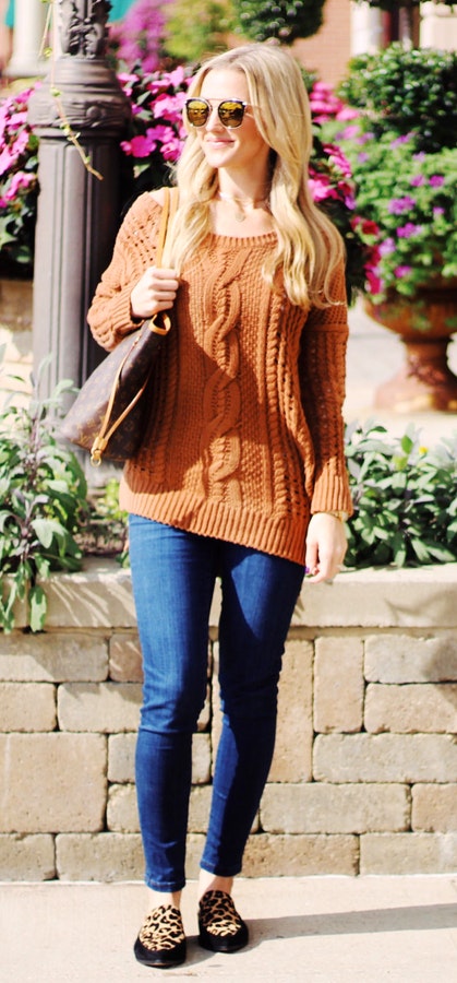 Women's brown cable knitted sweater and blue jeans.