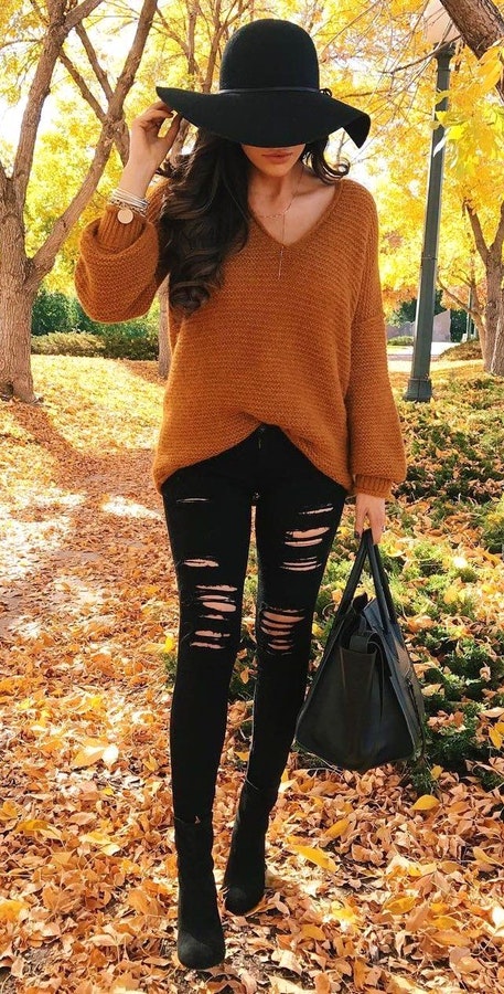Women's brown v-neck sweater with black distressed skinny jeans.