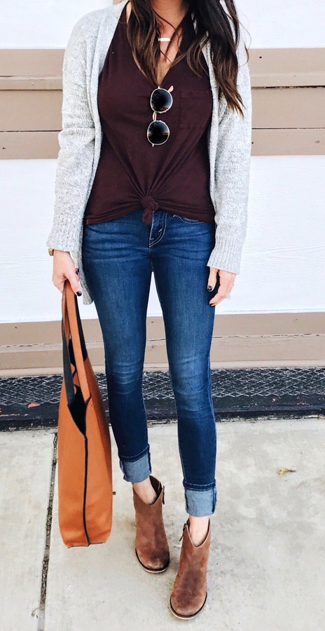 Women's gray cardigan, maroon scoop-neck shirt, and blue denim jeans.