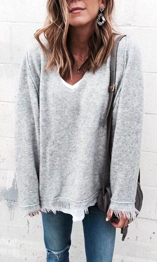 Women's gray sweater; blue denim jeans.