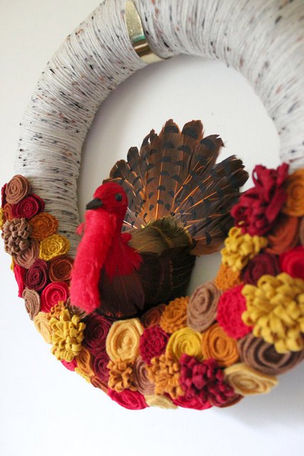 A felt rosettes wreath with a turkey at the center.