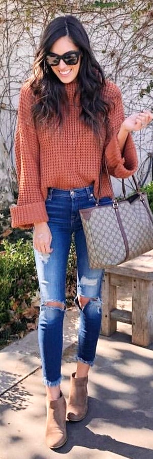 Brown knitted sweater, pair of blue distressed jeans and brown boots outfot.