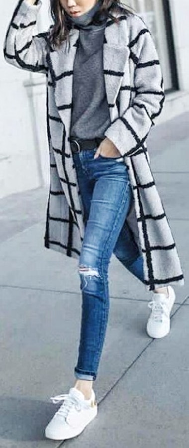 Gray and black overcoat, distressed blue-washed jeans and pair of white low-top sneakers outfit.