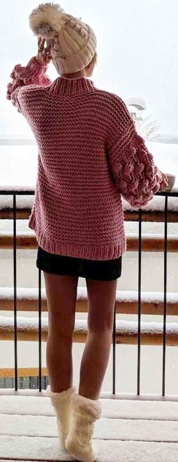 Pink knit sweater and bobble hat.